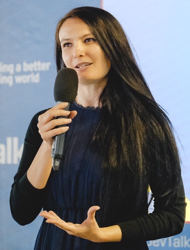 Veronica Stefan, a woman with long dark hair, speaking at a conference