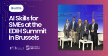 A photo of the AISHA consortium at the EDIH summit in Brussels on purple-pinkish background, with white text. Text reads: "AI skills for SMEs at the EDIH Summit in Brussels".