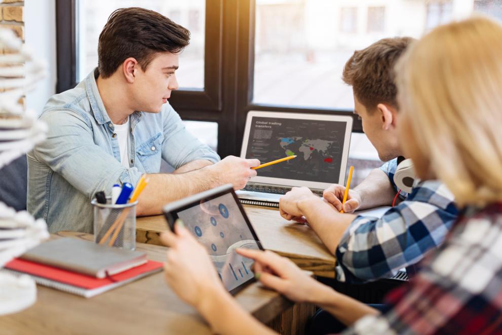 © Viacheslav Iakobchuk - stock.adobe.com Team working on a project with screen depicting map