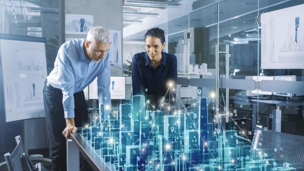 © Gorodenkoff - stock.adobe.com Male and female architects work with holographic augmented reality 3d city model