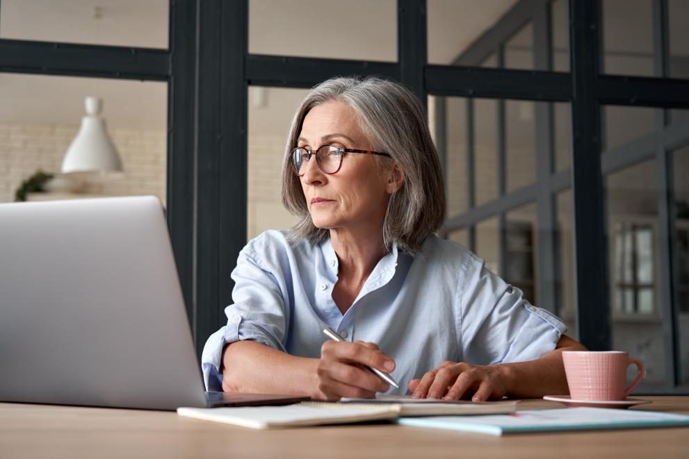 Woman completing training with laptop and notebook