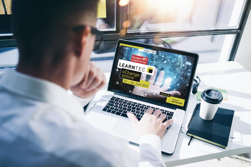 © KMK/Behrendt und Rausch Student next to his laptop seeing the learntech logo