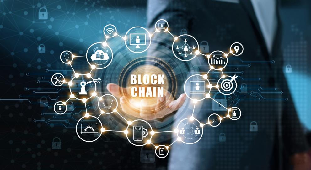 © ipopba - stock.adobe.com Graphic with a hand virtually holding digital technology symbols and the word Blockchain in the middle