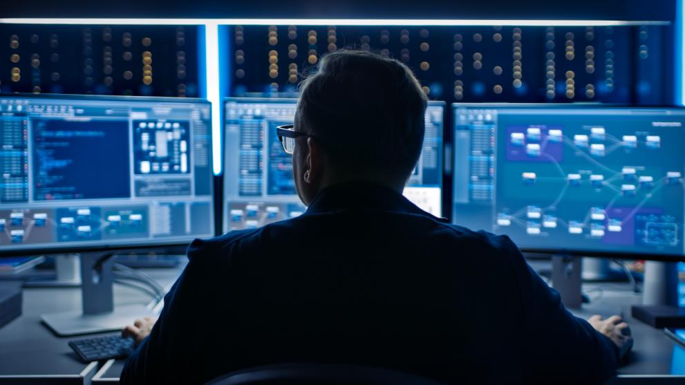 Cybersecurity expert working on several monitors