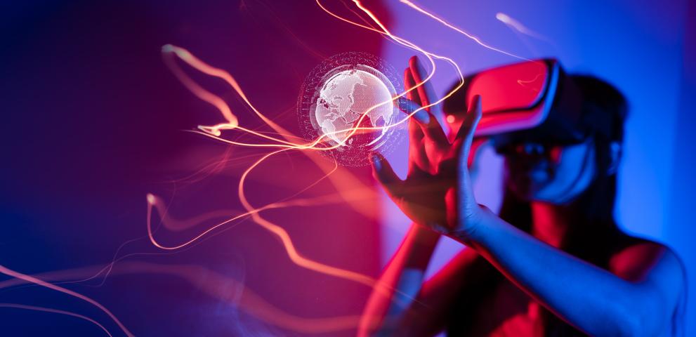 © Adobe Stock image of a woman wearing a VR headset and reaching out to a virtual projection of globe