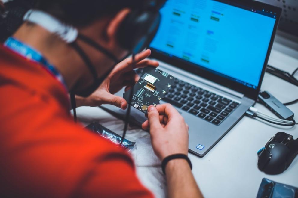 © European Cyber Security Challenge 2021/ENISA image of man working with circuit and computer