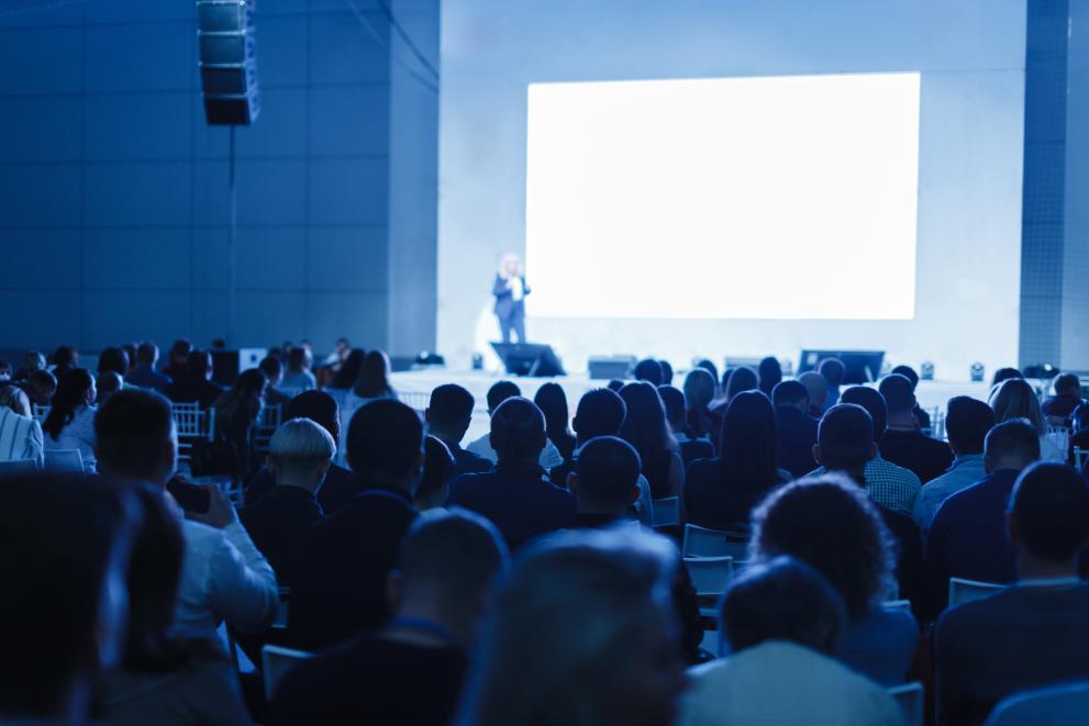 Business and Entrepreneurship concept. Speaker giving a talk in conference hall at business event. Audience at the conference hall