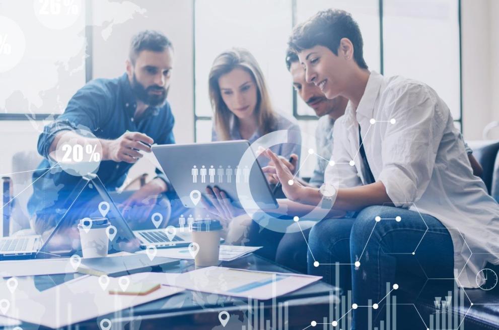 two young men and one young woman looking at a tablet and discussing something