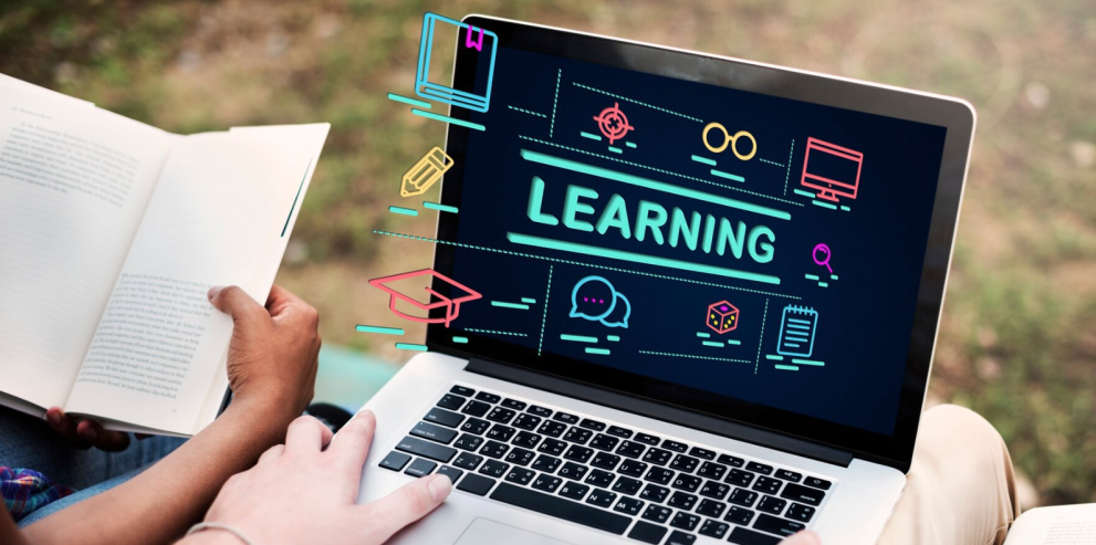 Hands holding a laptop with the words "Learning" written on it Hands holding a laptop with the words "Learning" written on it