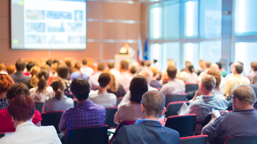 © Adobe Stock people sitting at a conference