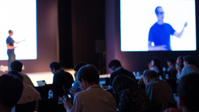 Man speaking on stage at conference