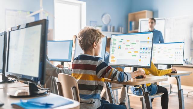 Students learning in classroom with computer screens