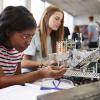 Two young women working on robotics