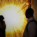 Photo of a man and woman backlit by a photo of a ring of light.