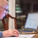 An old man in front of a computer